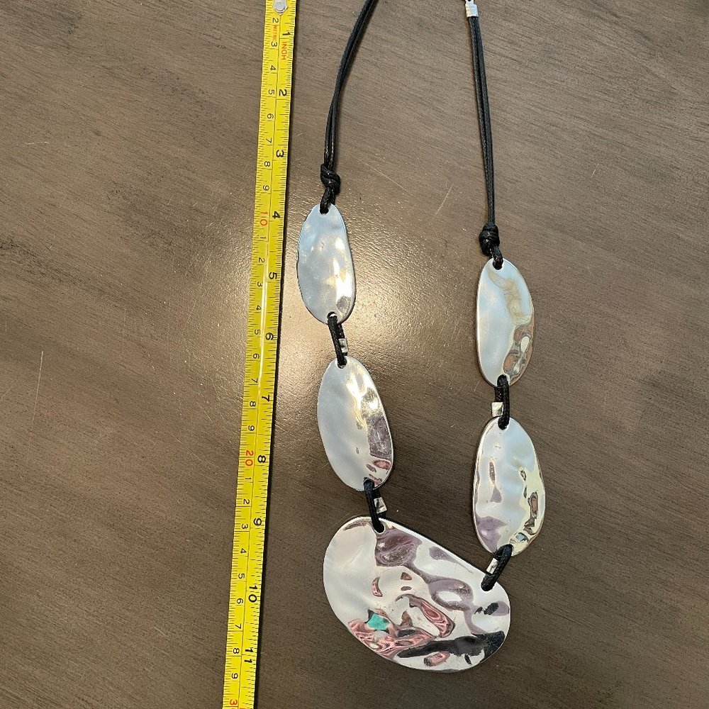 Hammered metal statement necklace on cloth cord